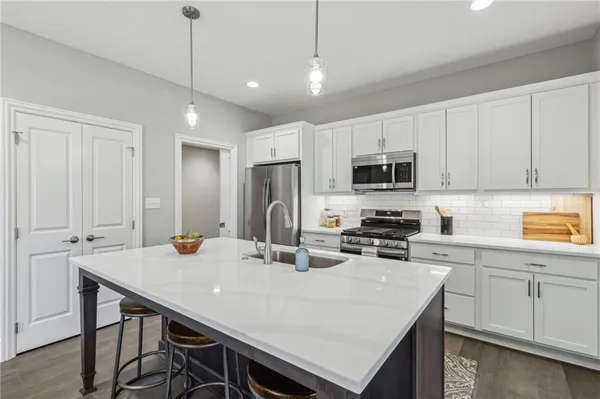 a kitchen with kitchen island a table and chairs