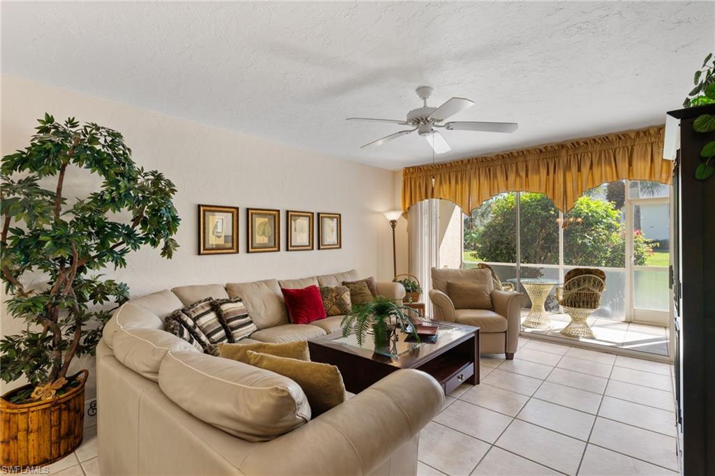 776 Landover Circle, Unit 104 Naples, FL 34104 - Photo 11 of 25 a living room with furniture and a large window
