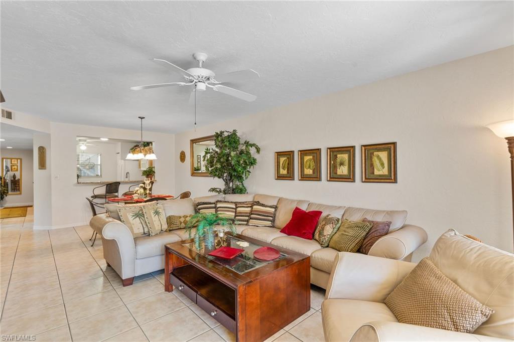 776 Landover Circle, Unit 104 Naples, FL 34104 - Photo 12 of 25 a living room with furniture and a large window