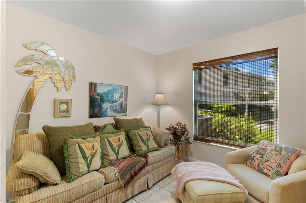 776 Landover Circle, Unit 104 Naples, FL 34104 - Photo 14 of 25 a living room with furniture and a window