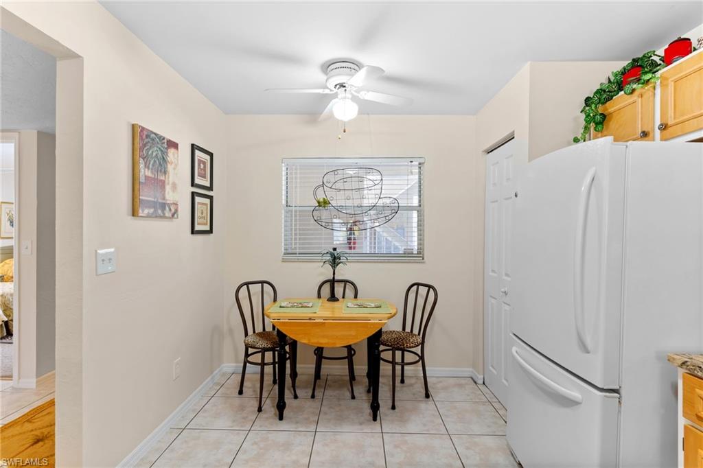 776 Landover Circle, Unit 104 Naples, FL 34104 - Photo 5 of 25 a view of a dining room with furniture and a chandelier fan