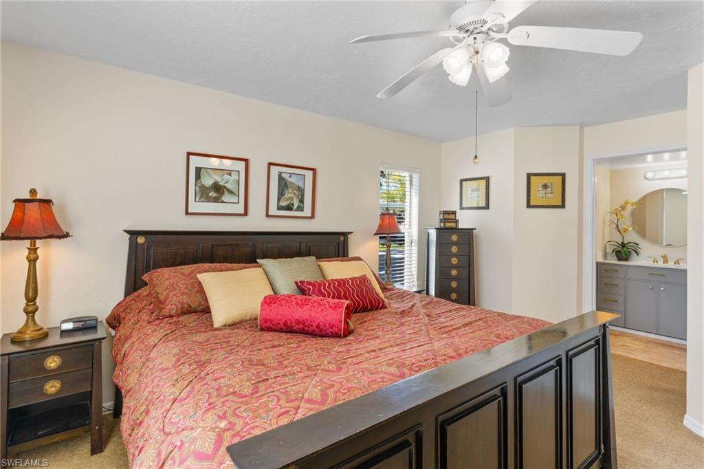 776 Landover Circle, Unit 104 Naples, FL 34104 - Photo 8 of 25 a bedroom with a bed and a chandelier