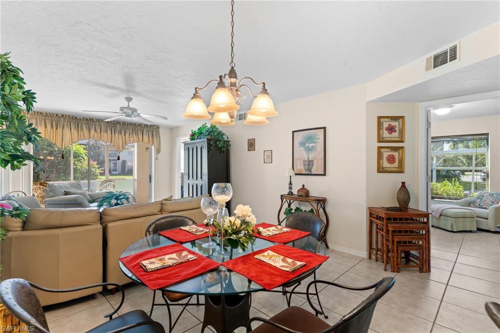 776 Landover Circle, Unit 104 Naples, FL 34104 - Photo 9 of 25 a living room with furniture a window and a chandelier