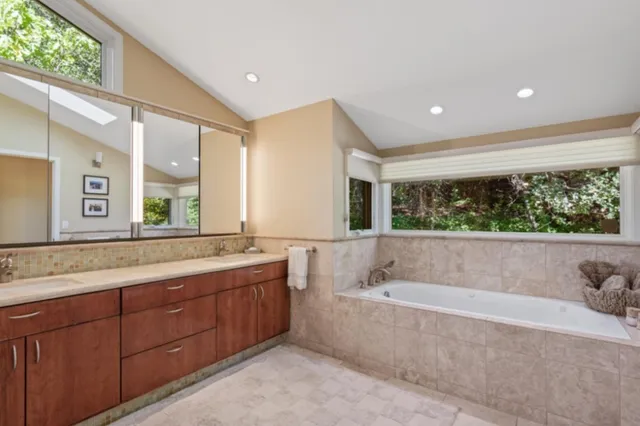 a spacious bathroom with a tub sink and mirror