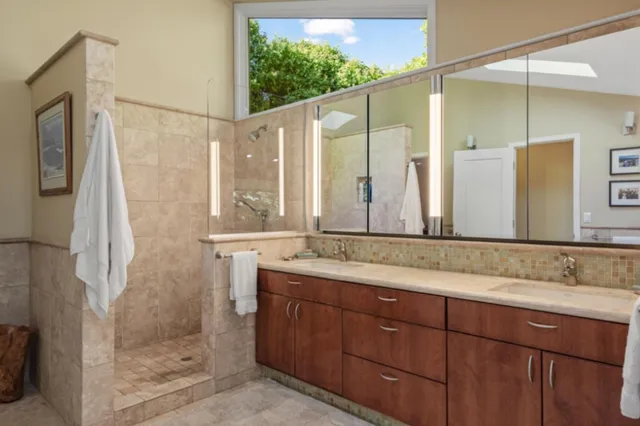a bathroom with a granite countertop sink mirror and a shower