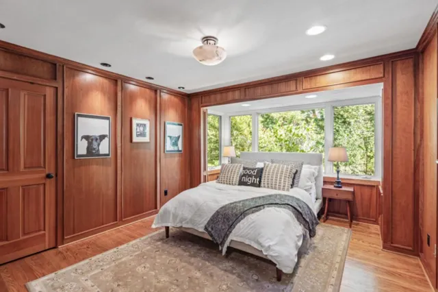 a bed sitting in a spacious bedroom next to a window