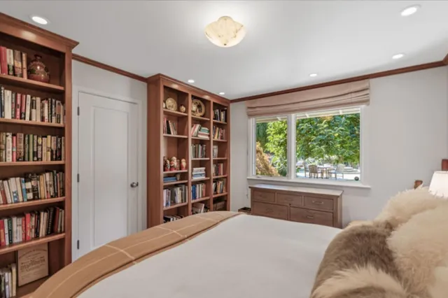 a bedroom with a bed and a book shelf