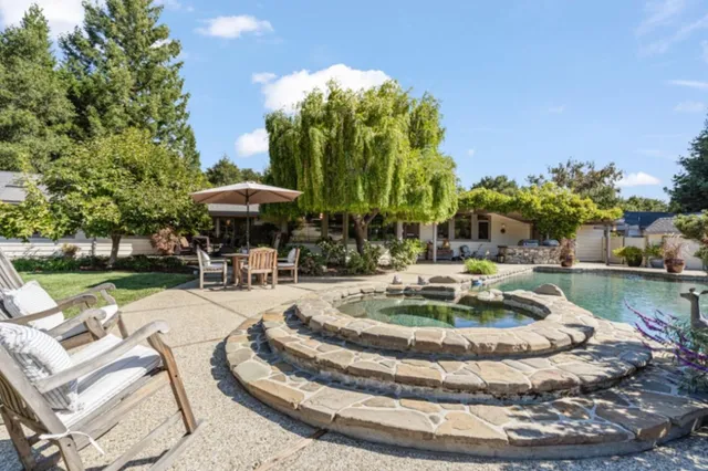 a swimming pool with outdoor seating yard and barbeque oven
