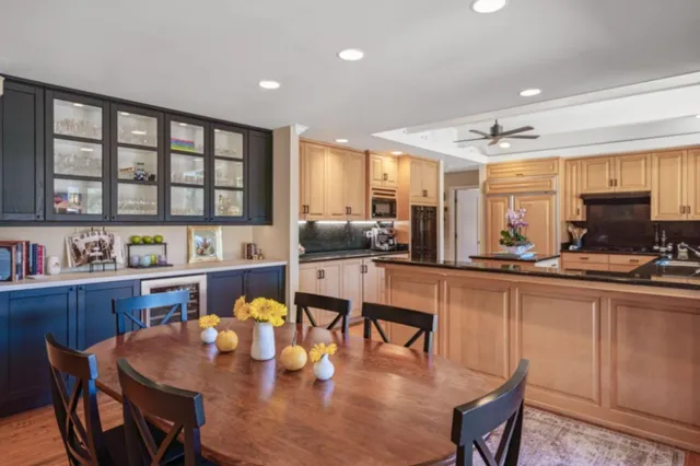 a kitchen with stainless steel appliances granite countertop a stove a sink a dining table and chairs