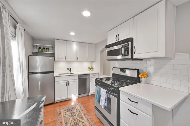 a kitchen with stainless steel appliances a refrigerator and a stove top oven