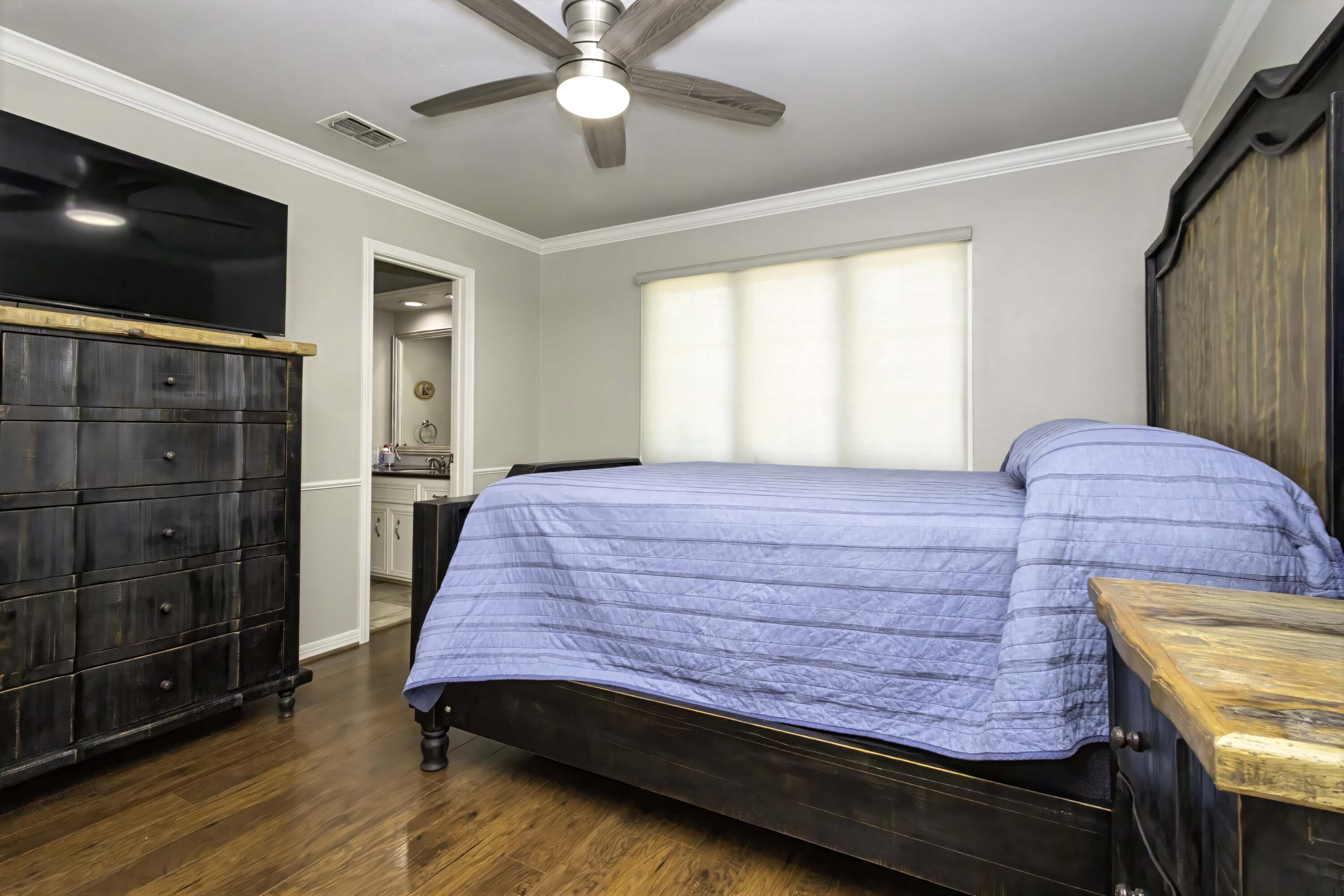5101 2nd Street Lubbock, TX 79416 - Photo 27 of 41 a bedroom with a bed and a flat screen tv