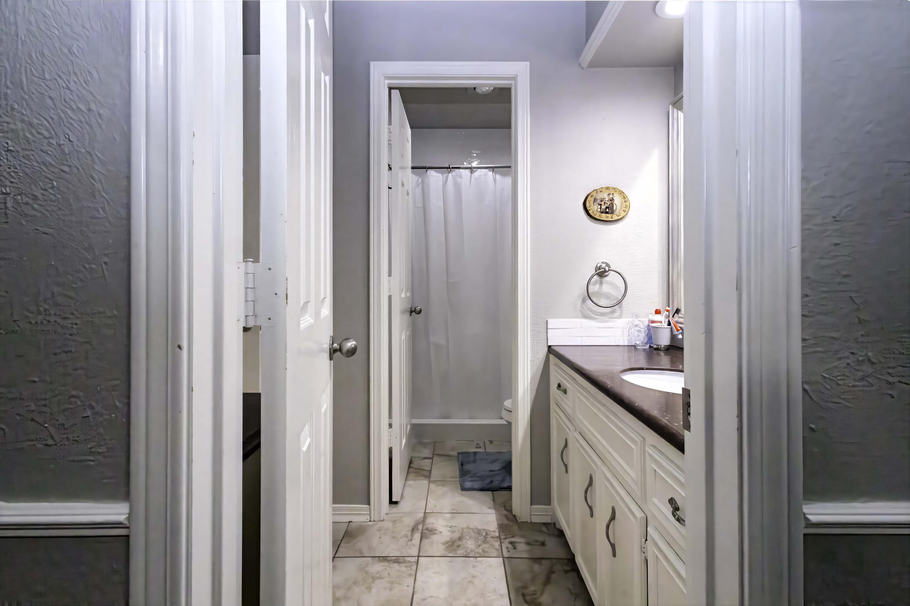 5101 2nd Street Lubbock, TX 79416 - Photo 28 of 41 a bathroom with a double vanity sink a mirror and a shower