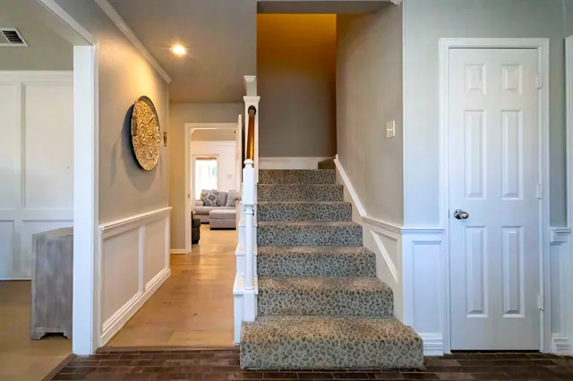 a bedroom with a bed and a dresser next to a window