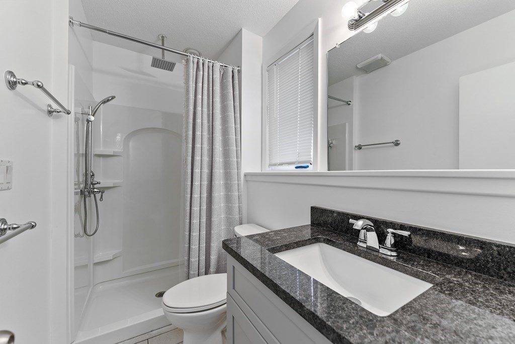 54 Kennedy Street Chicopee, MA 01013 - Photo 30 of 42 a bathroom with a granite countertop sink toilet a mirror and shower