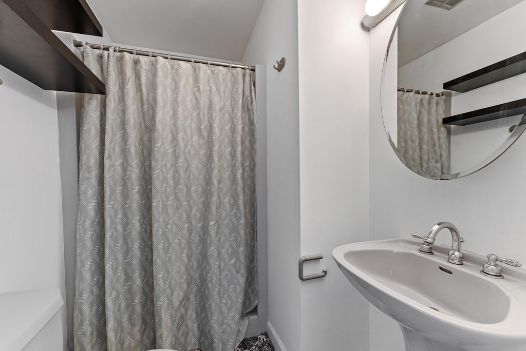 54 Kennedy Street Chicopee, MA 01013 - Photo 38 of 42 a bathroom with a sink a mirror and a shower curtain