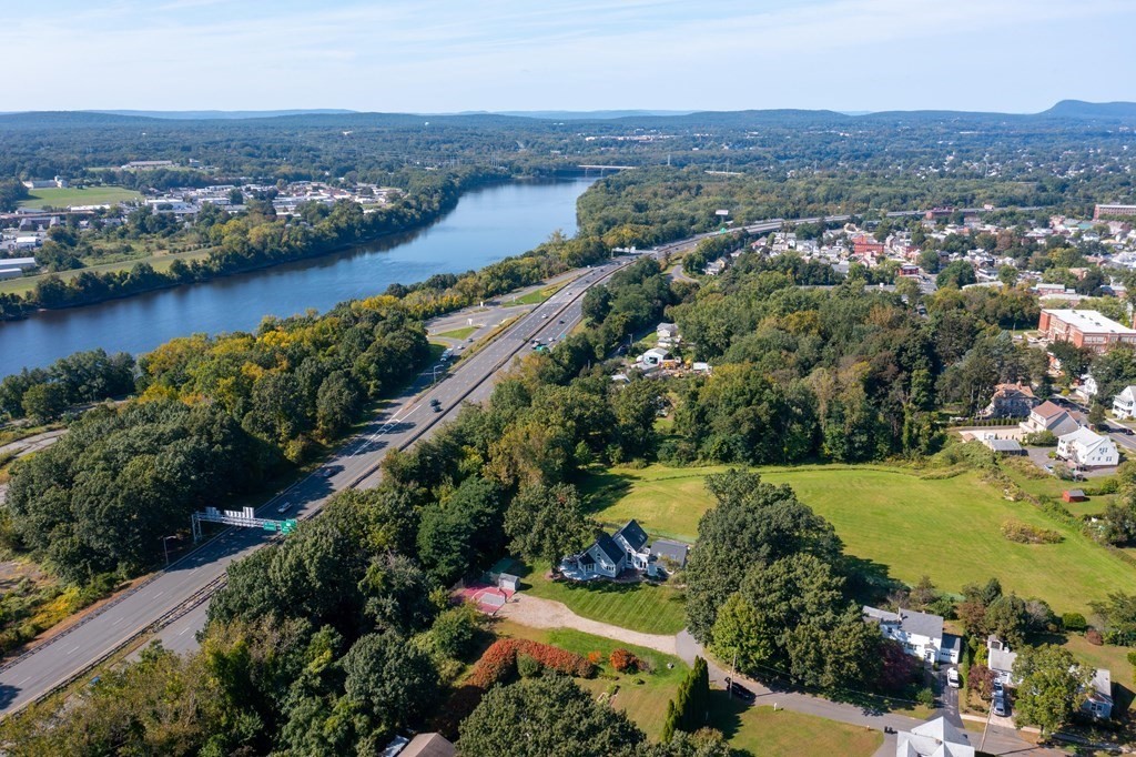 54 Kennedy Street Chicopee, MA 01013 - Photo 4 of 42 an aerial view of green landscape with trees houses and lake view