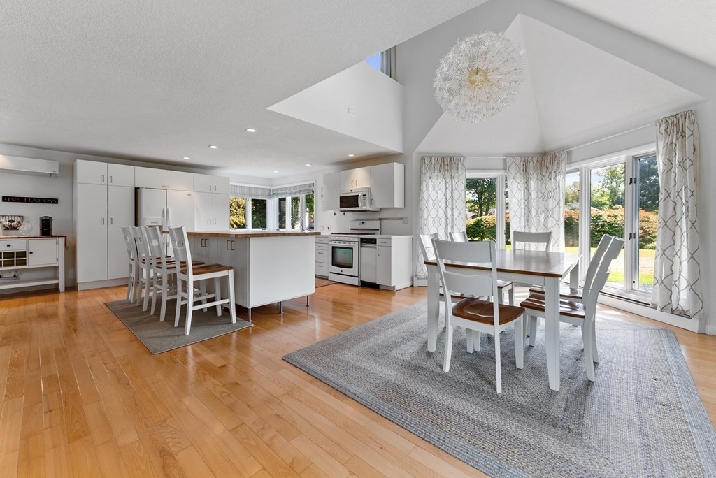 54 Kennedy Street Chicopee, MA 01013 - Photo 10 of 42 a dining room with wooden floor a chandelier a wooden table and chairs