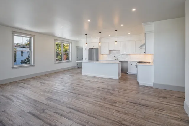 a large kitchen with cabinets wooden floor and a sink