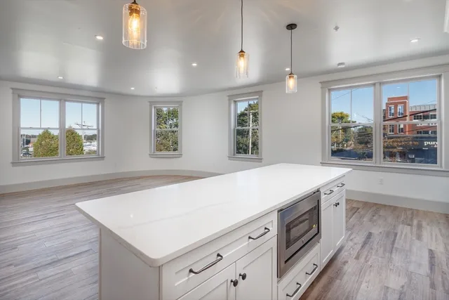 a kitchen with a stove and a wooden floor