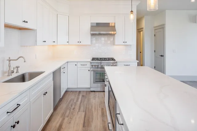 a kitchen with a sink a stove and cabinets