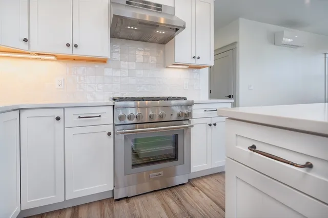 a kitchen with white cabinets and appliances