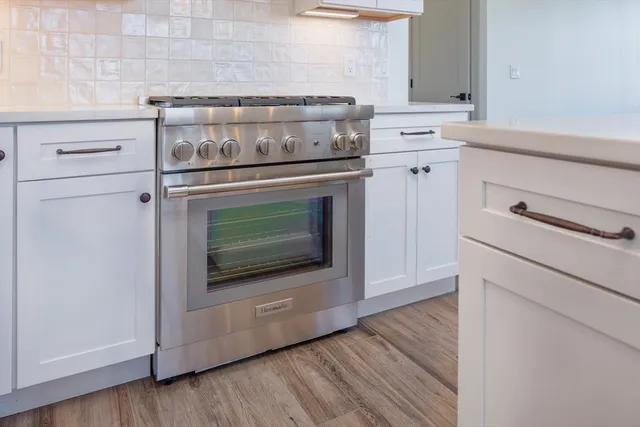 a stove top oven sitting inside of a kitchen
