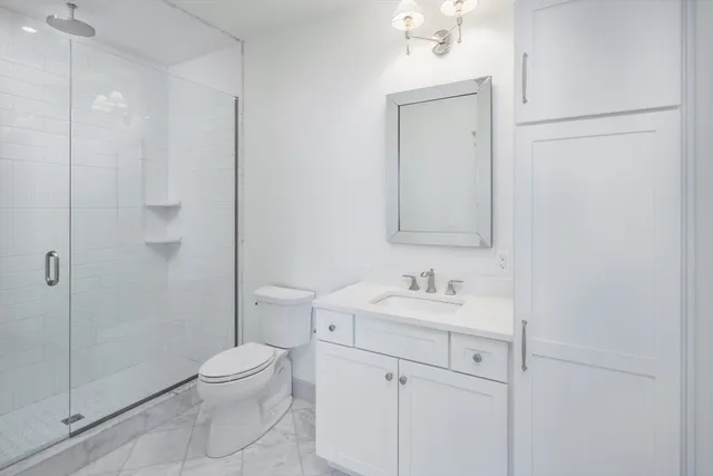 a bathroom with a toilet sink vanity and mirror