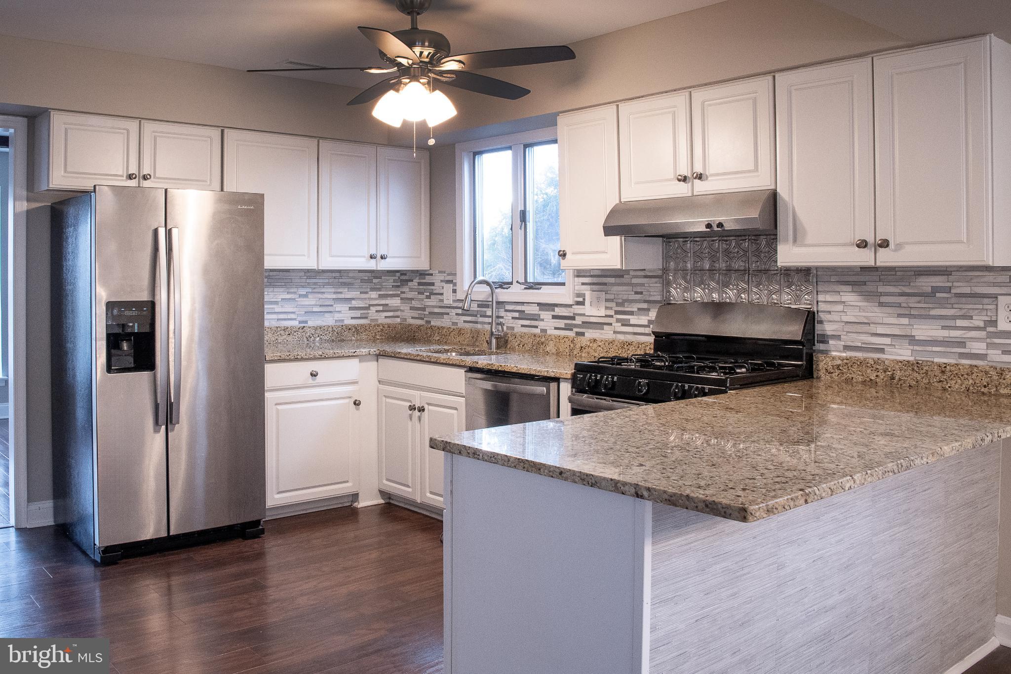22 Duncan Road Sewell, NJ 08080 - Photo 23 of 46 a kitchen with stainless steel appliances granite countertop a refrigerator a stove a sink and white cabinets