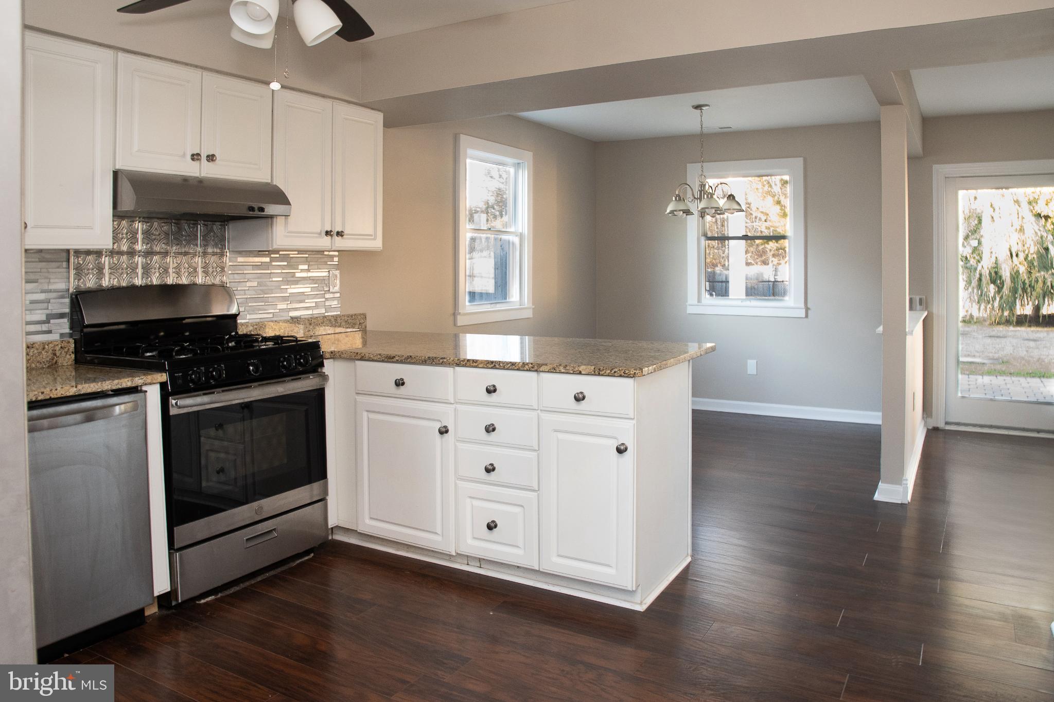 22 Duncan Road Sewell, NJ 08080 - Photo 25 of 46 a kitchen with stainless steel appliances a white stove top oven cabinets and a wooden floor