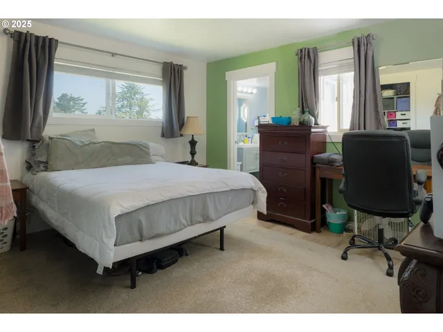 a bedroom with a bed and large windows