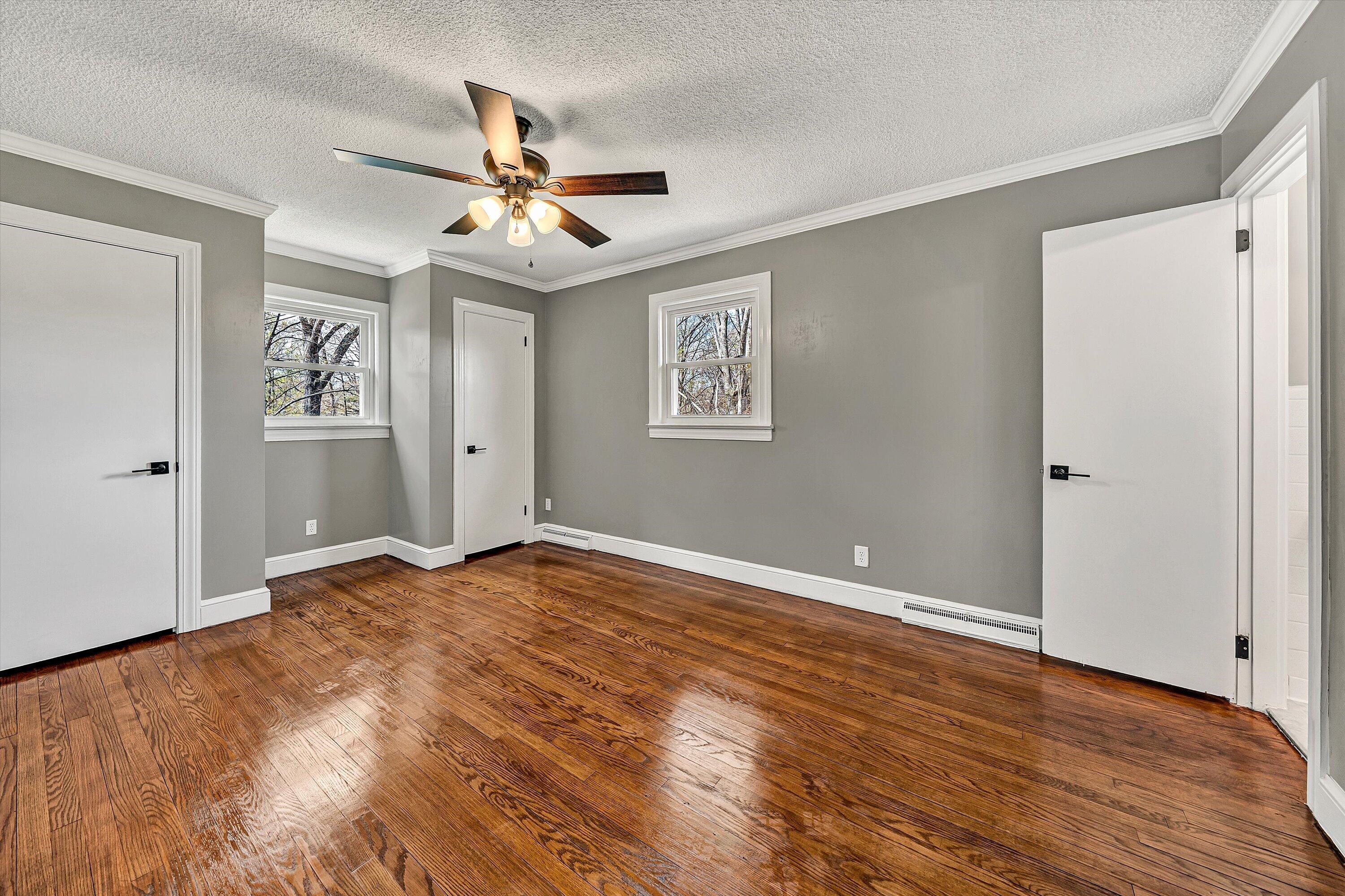 731 Bassett Heights Road Bassett, VA 24055 - Photo 19 of 45 an empty room with wooden floor ceiling fan and windows