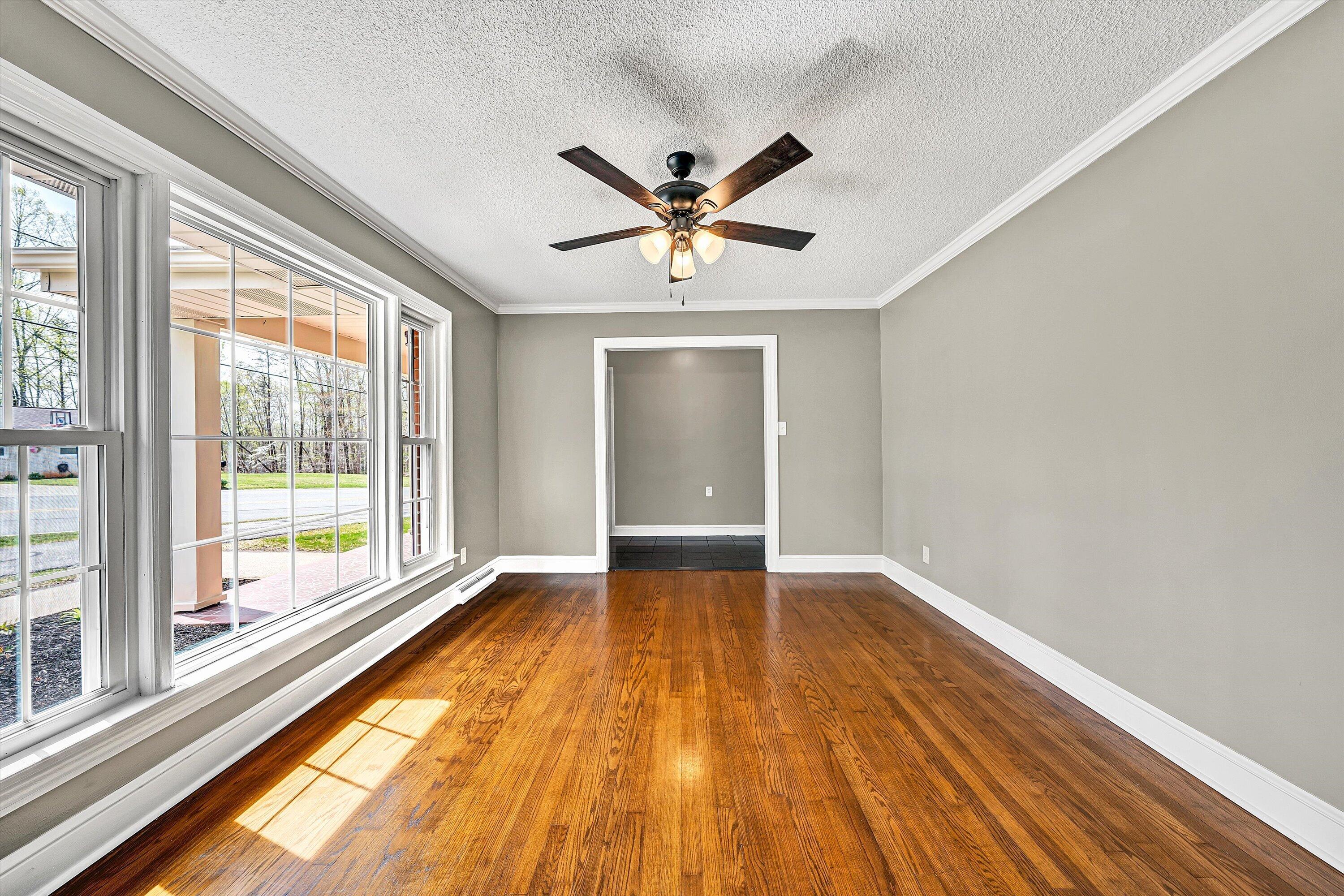 731 Bassett Heights Road Bassett, VA 24055 - Photo 9 of 45 a view of an empty room with window and wooden floor