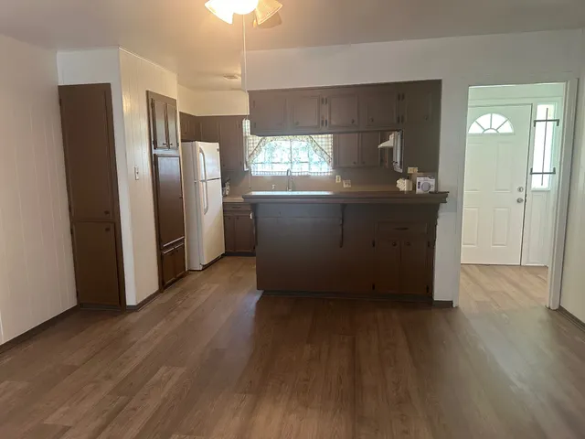 a kitchen with stainless steel appliances wooden floors and wooden cabinets