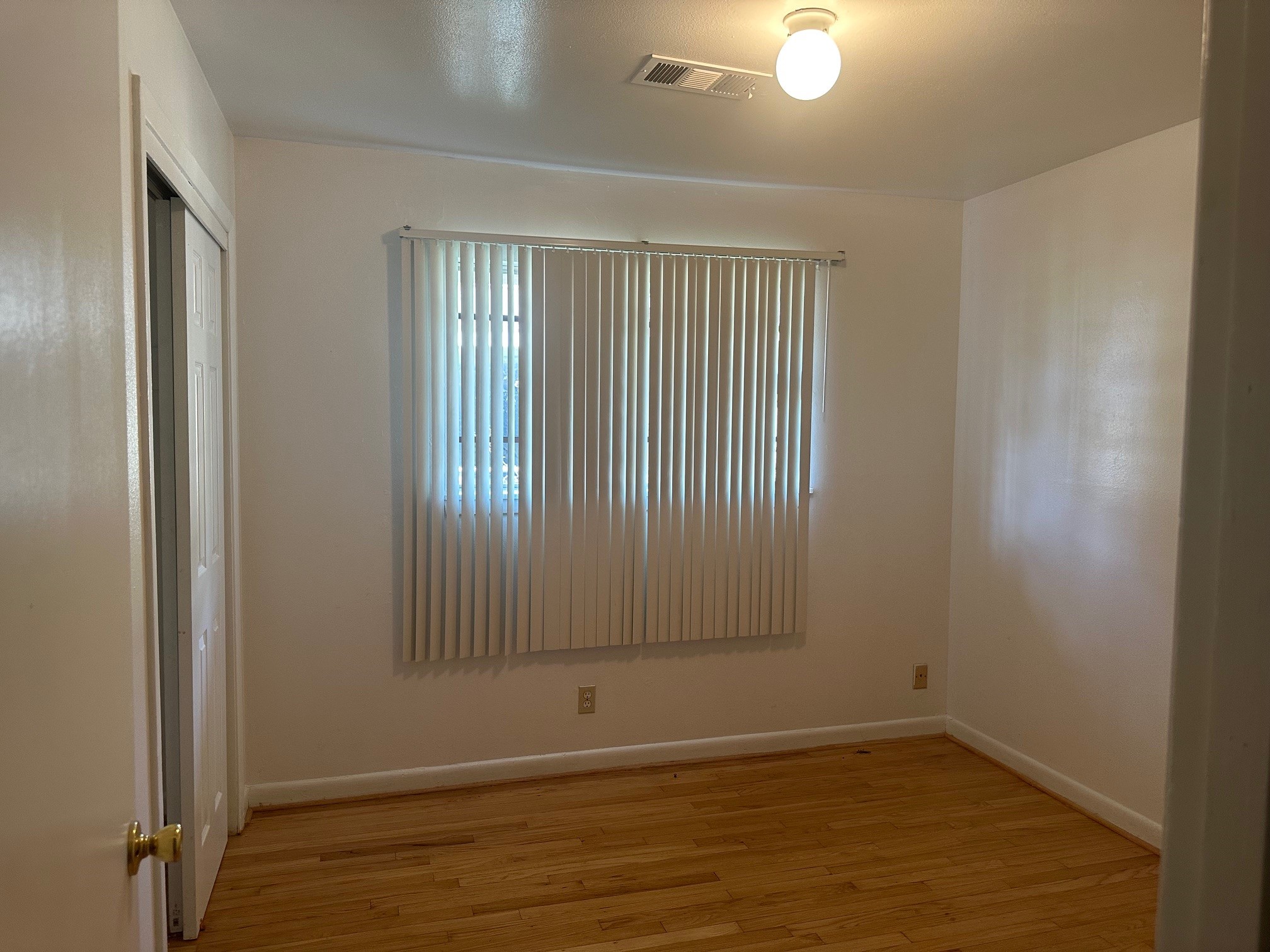 6003 Heatherbrook Drive Houston, TX 77085 - Photo 8 of 13 an empty room with wooden floor and windows