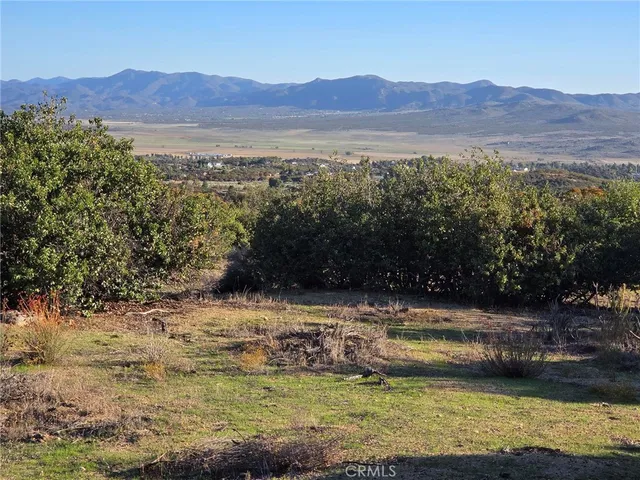 a view of a field with mountains in the background