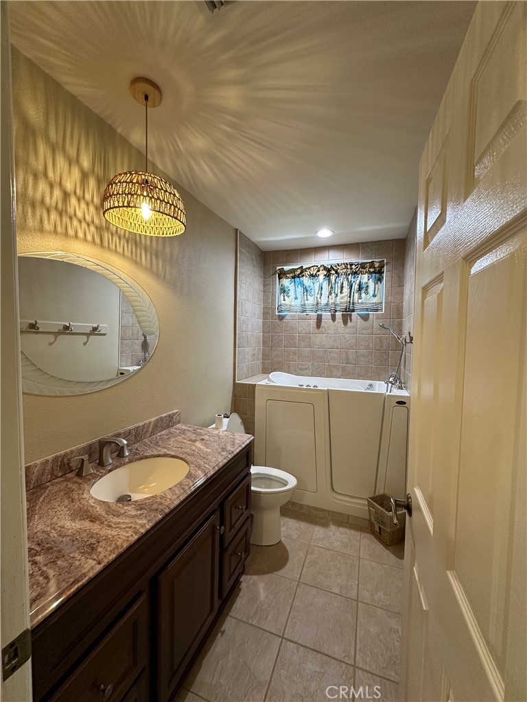 6707 Rycroft Drive Riverside, CA 92506 - Photo 12 of 41 a bathroom with a granite countertop sink a toilet and mirror