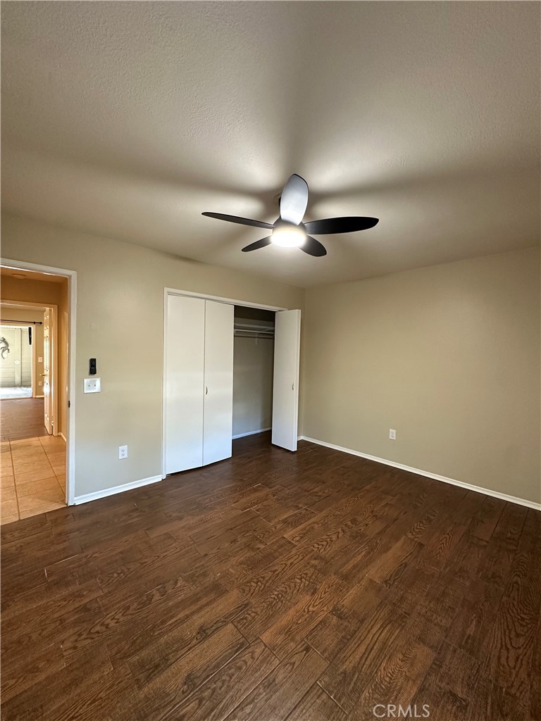 6707 Rycroft Drive Riverside, CA 92506 - Photo 20 of 41 a view of an empty room with wooden floor and a ceiling fan
