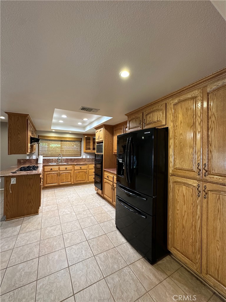 6707 Rycroft Drive Riverside, CA 92506 - Photo 23 of 41 a kitchen with granite countertop a refrigerator and a sink