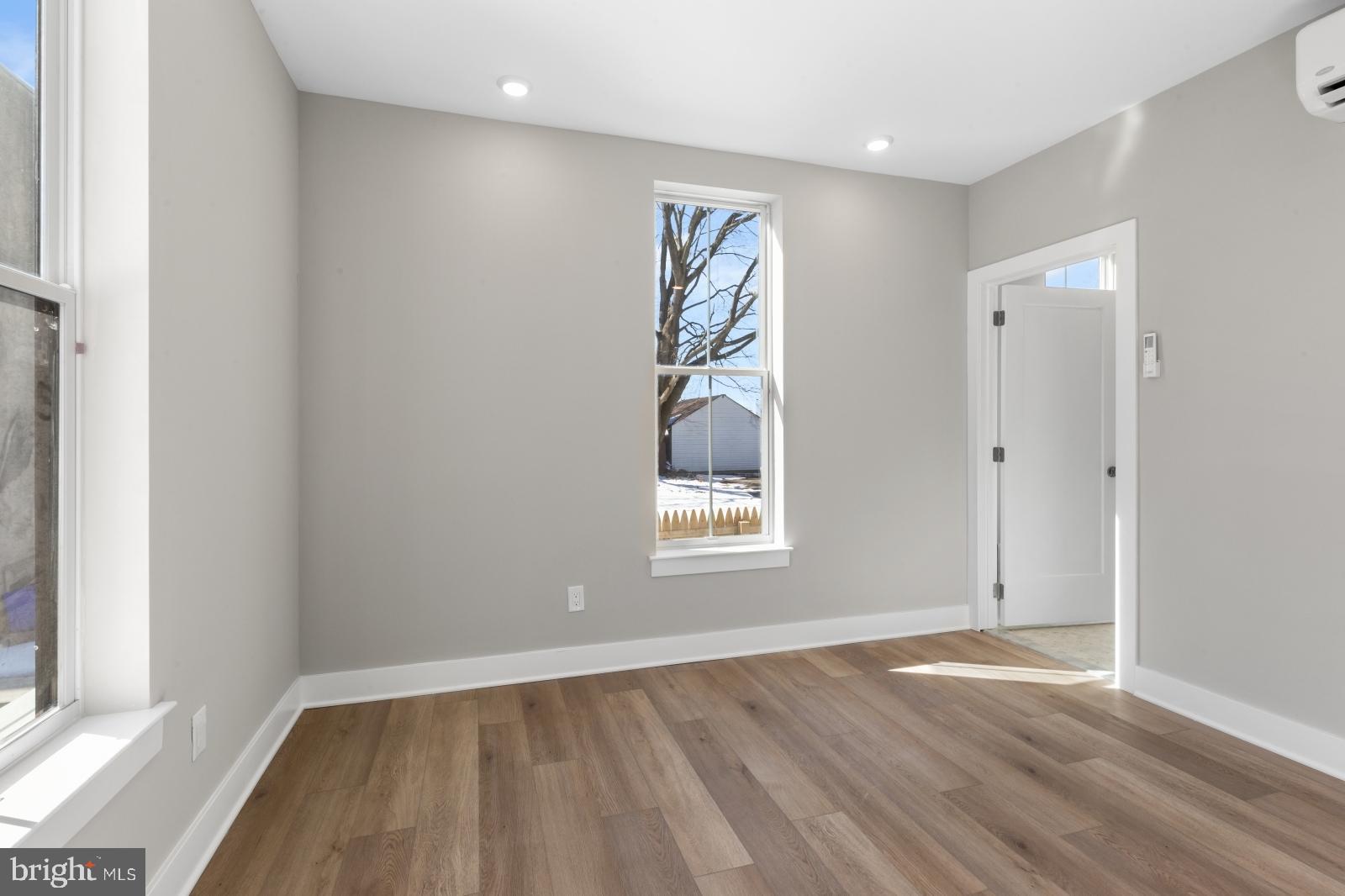 6712 Ridge Avenue, Unit 204 Philadelphia, PA 19128 - Photo 9 of 18 an empty room with wooden floor and windows