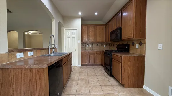 a kitchen with stainless steel appliances granite countertop a sink a stove and a refrigerator