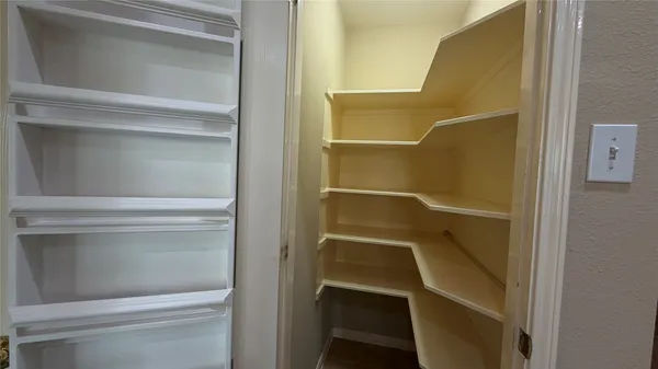 a view of walk in closet with empty racks