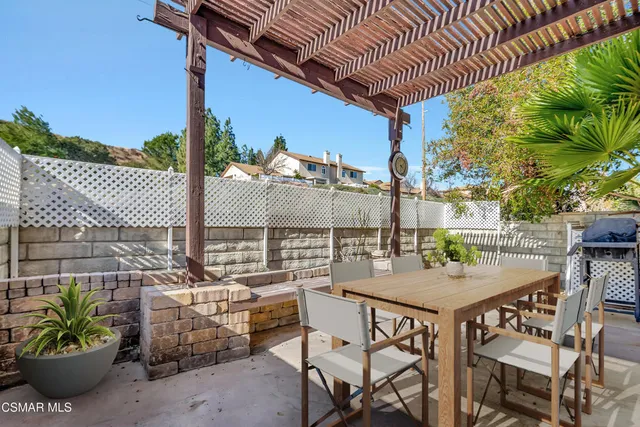 a view of a patio with a table and chairs and potted plants