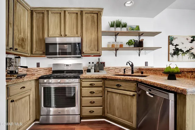 a kitchen with stainless steel appliances granite countertop a stove sink and cabinets