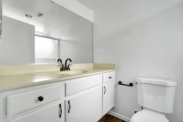 a bathroom with a sin toilet sink and mirror
