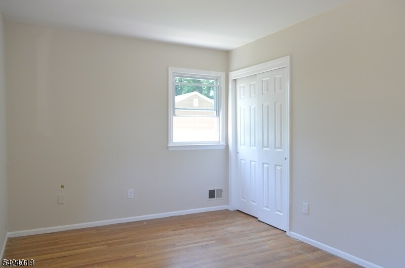 89 Forsythia Lane, Unit A Paramus, NJ 07652 - Photo 12 of 12 a view of an empty room with wooden floor and a window