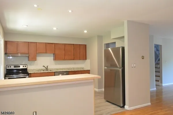 a kitchen with stainless steel appliances granite countertop a refrigerator a sink and a stove