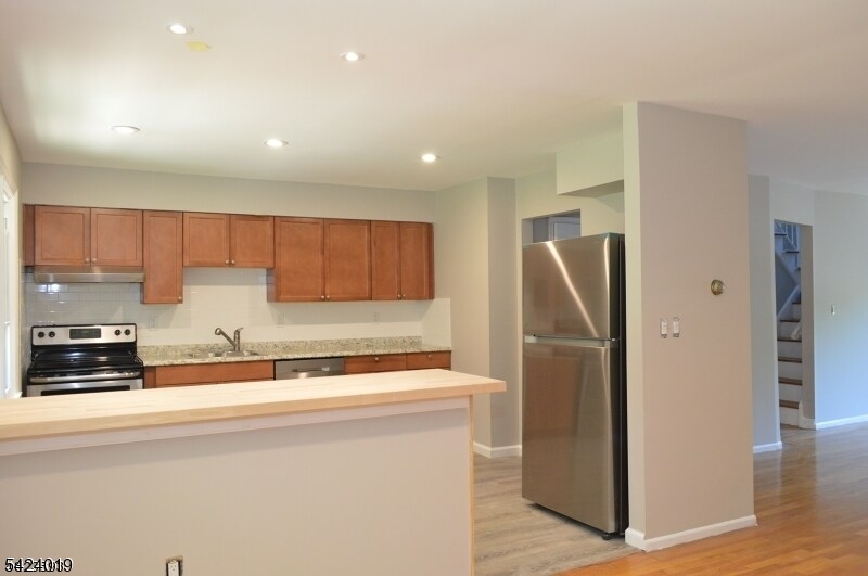 89 Forsythia Lane, Unit A Paramus, NJ 07652 - Photo 2 of 12 a kitchen with stainless steel appliances granite countertop a refrigerator a sink and a stove