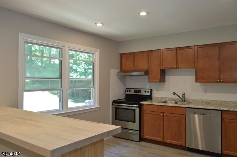 89 Forsythia Lane, Unit A Paramus, NJ 07652 - Photo 3 of 12 a kitchen with granite countertop a stove a sink and a cabinets