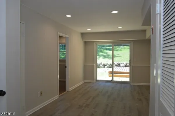 an empty room with wooden floor and a window