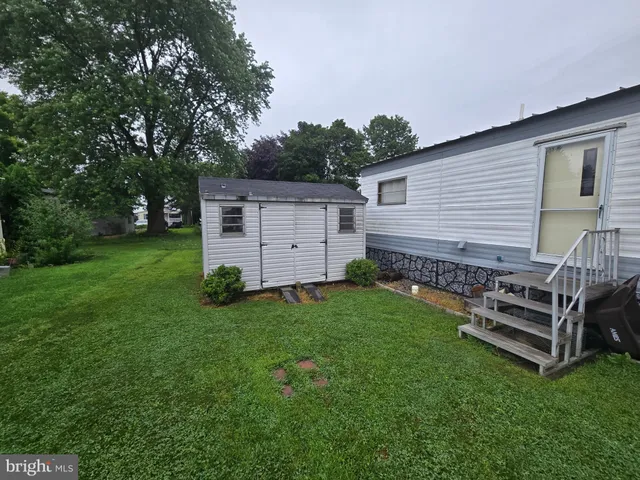 a view of a house with backyard and wooden fence